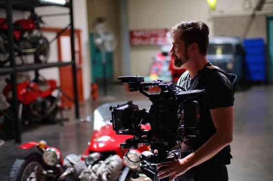 Nick Schwyter operating a cinema camera inside a workshop during a Polytech production.