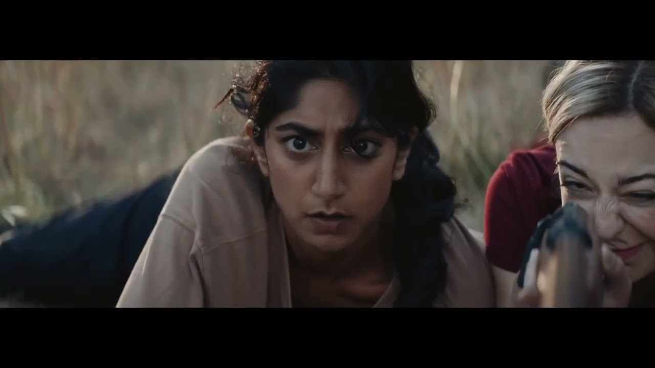 A woman looks toward camera in a natural outdoor scene from Wilder Than Her.